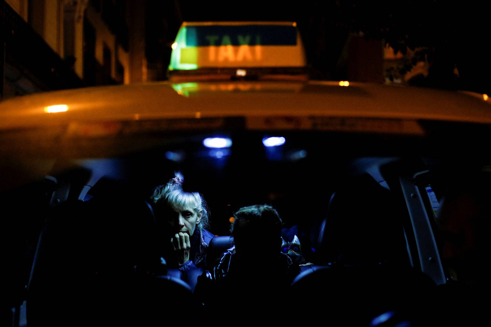 A Ukrainian woman and her family sit in a taxi with the colours of the Ukrainian flag upon arriving in Madrid