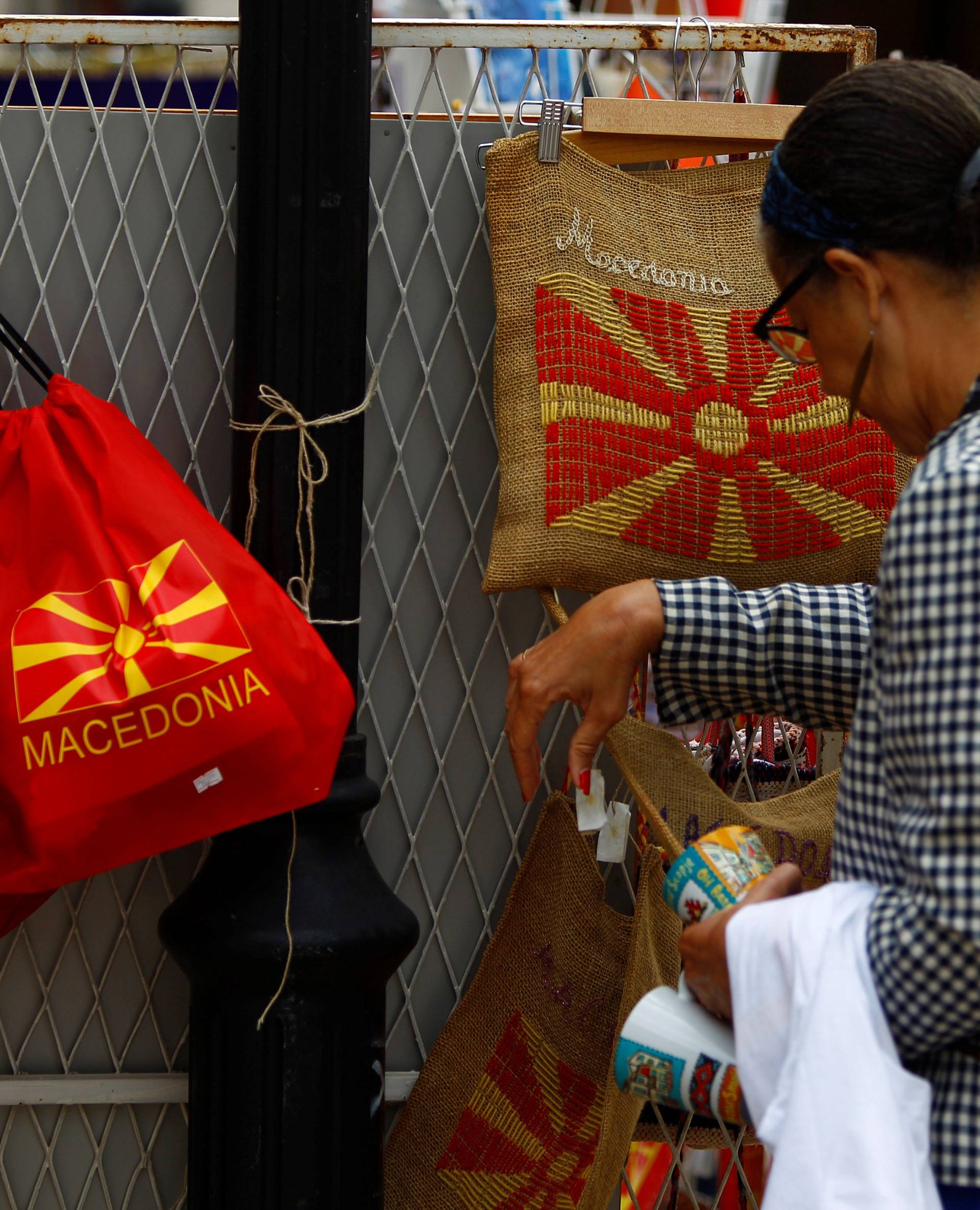 Tourists look at souvenirs with Macedonian flag on at the Old Bazar in Skopje