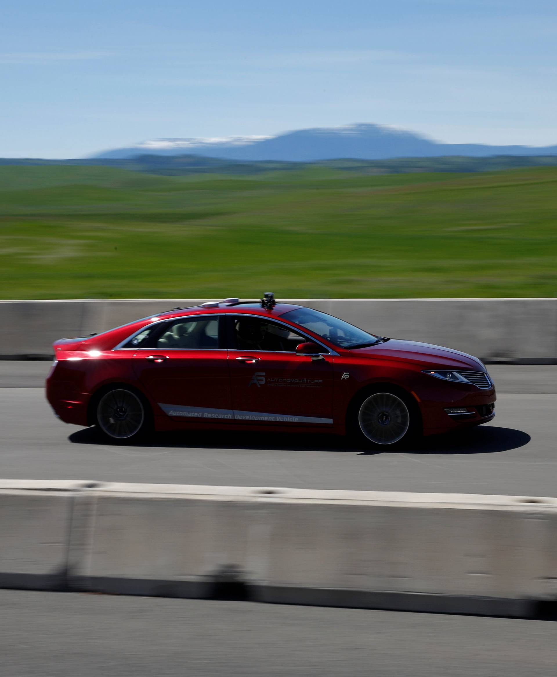 An AutonomouStuff Automated Research Development Vehicle drives on the race track during a self-racing cars event at Thunderhill Raceway in Willows, California