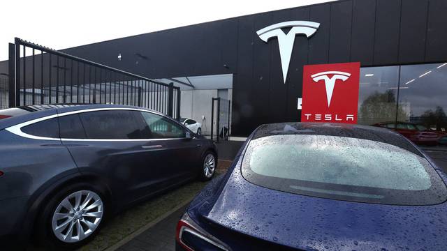 Tesla electric vehicles are parked outside a dealership in Drogenbos