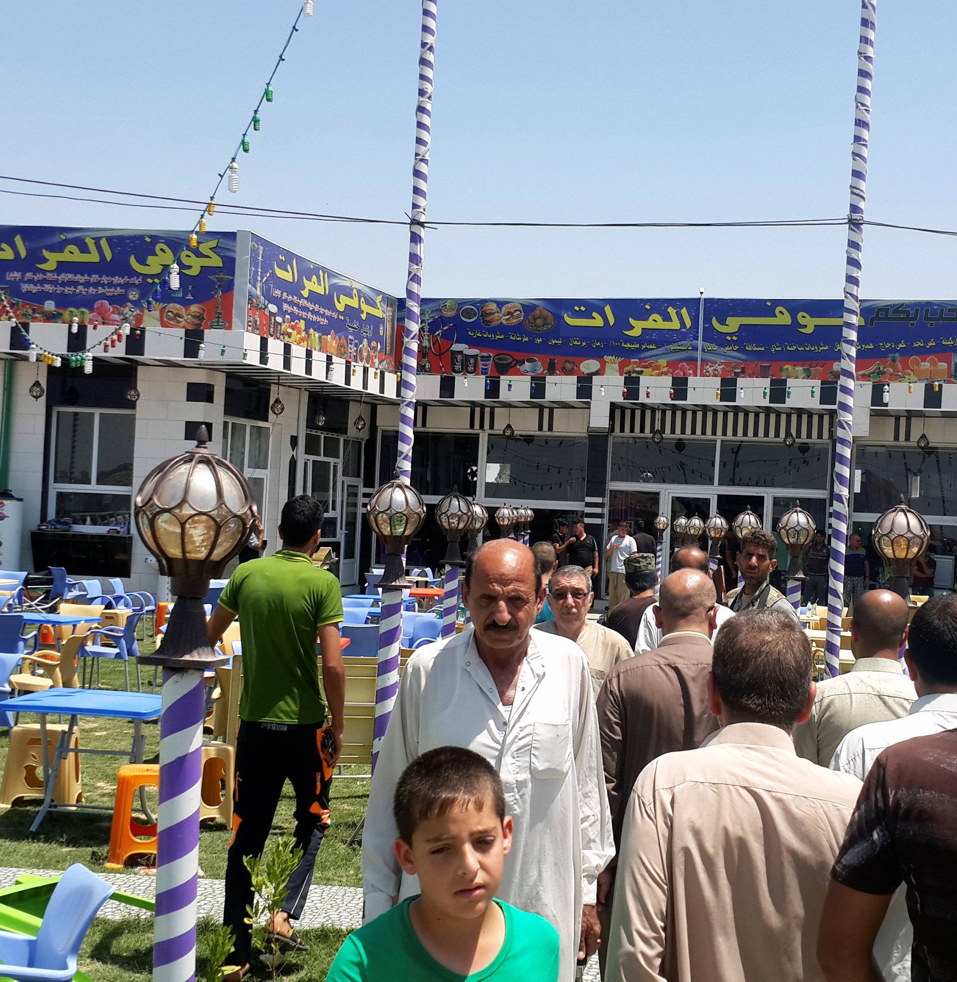 People gather at a cafe after an attack in the predominately Shi'ite Muslim town of Balad