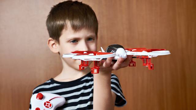 Little boy with toy quadcopter drone
