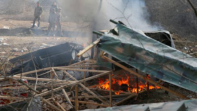 Ethnic Armenian soldiers stand next to a burning mock-up of a tank in the village of Knaravan