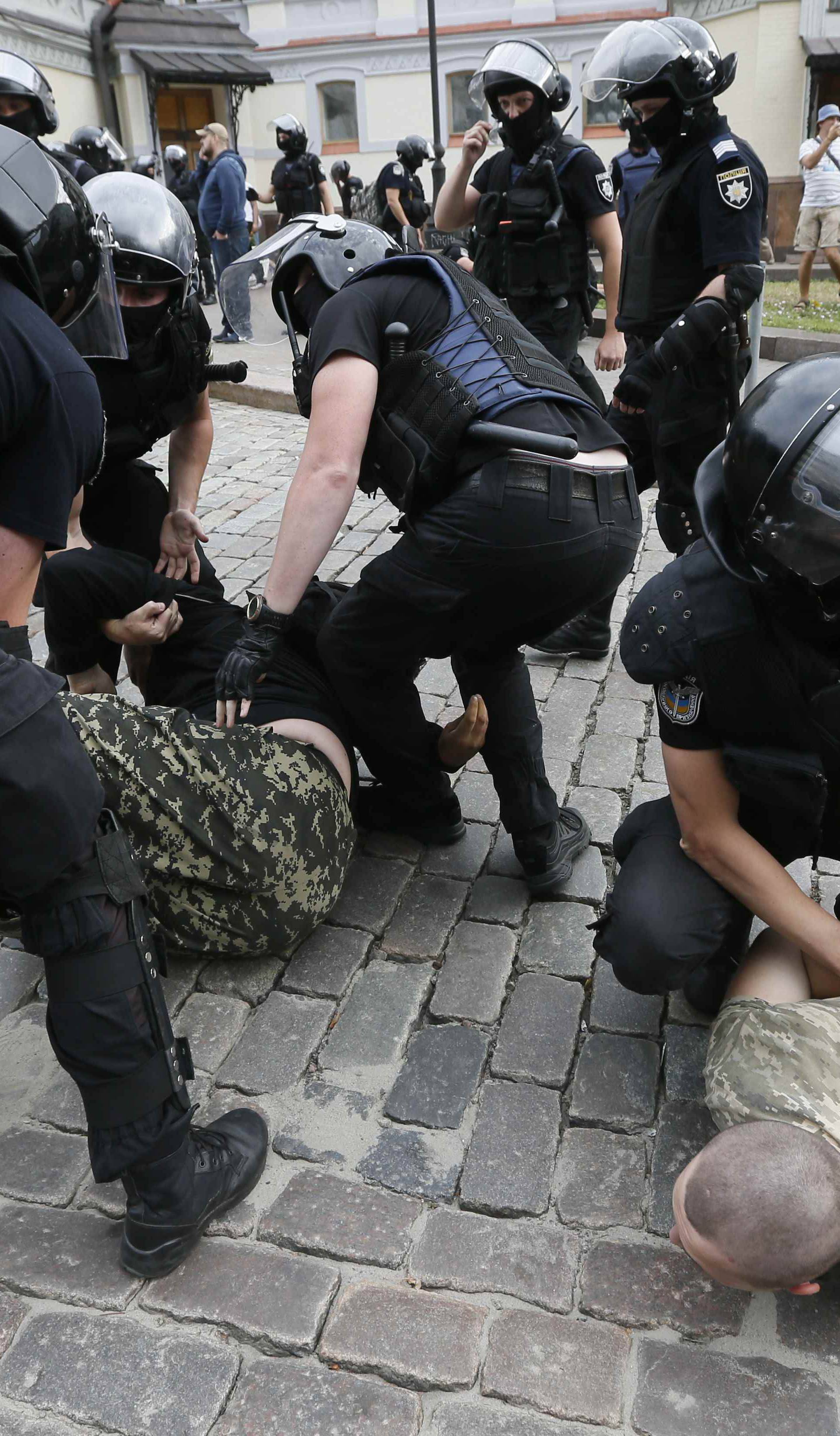 Riot police officers detain anti-LGBT protesters during the Equality March in Kiev