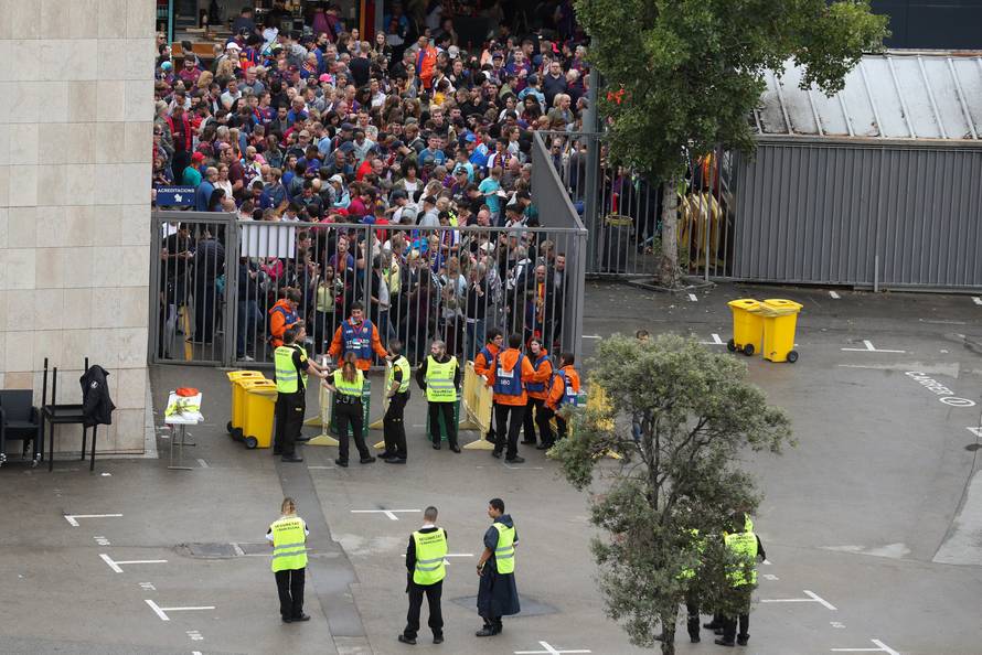People wait outside Camp Nou stadium for news on whether the Spanish La Liga soccer match between Barcelona and Las Palmas will go ahead as planned in Barcelona