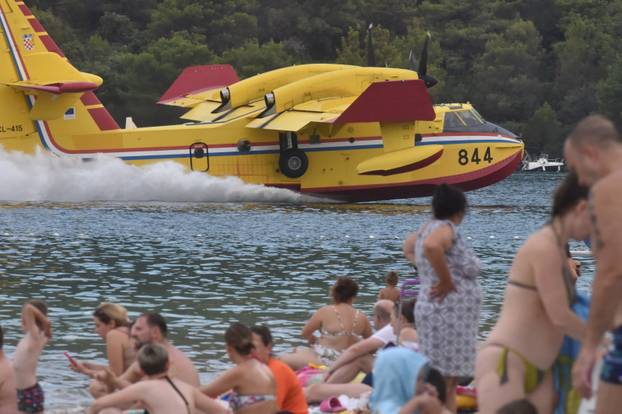 Turisti s plaže u Grebaštici s neposredne blizine promatrali kanadere kako uzimaju vodu za gašenje požara