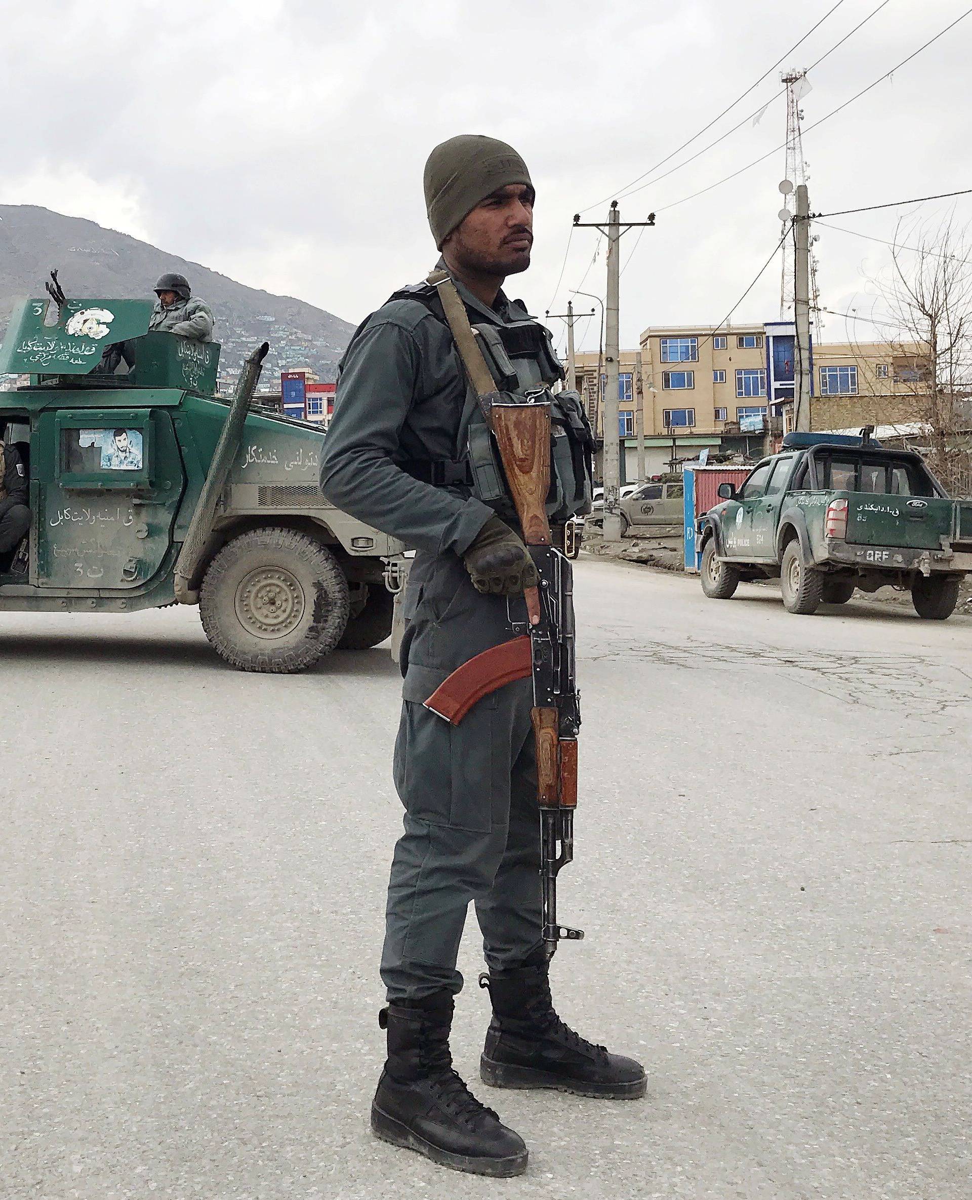 An Afghan policeman stands guard near the site of an attack in Kabul,
