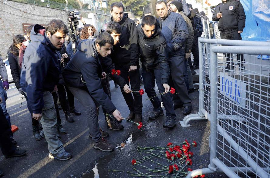 Men lay flowers outisde the Reina nightclub by the Bosphorus, which was attacked by a gunman, in Istanbul