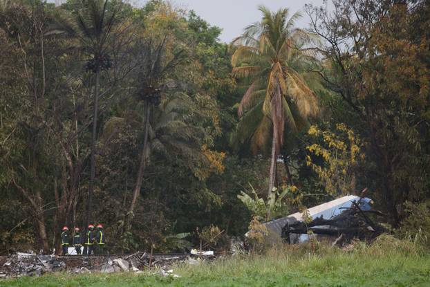 Firefighters work at the wreckage site of a Boeing 737 plane that crashed in the agricultural area of Boyeros