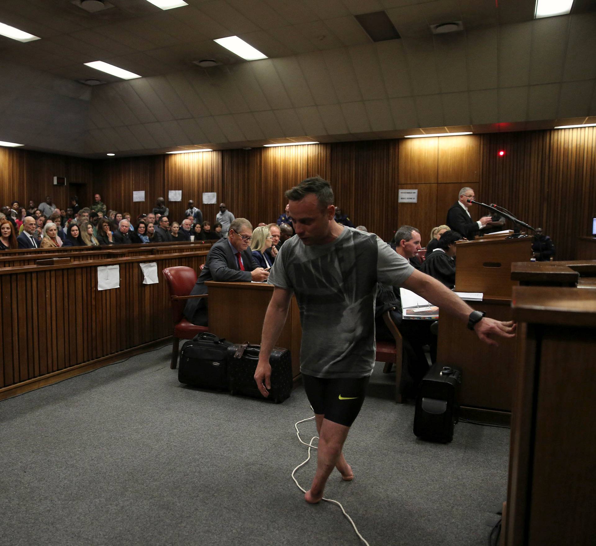 Paralympic gold medalist Oscar Pistorius walks across the courtroom without his prosthetic legs during the third day of the resentencing hearing for the 2013 murder of his girlfriend Reeva Steenkamp, at Pretoria High Court