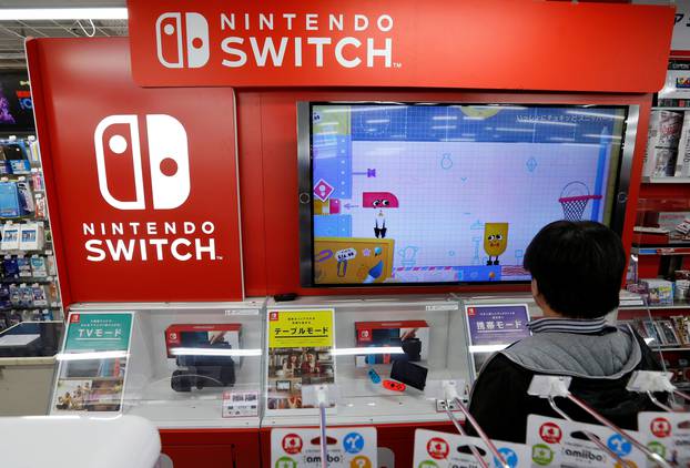 Logos of Nintendo Switch game console are seen at an electronics store in Tokyo