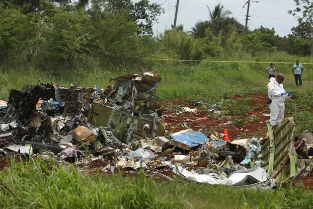 A rescue team member works at the wreckage of a Boeing 737 plane that crashed in the agricultural area of Boyeros, around 20 km south of Havana