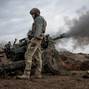 FILE PHOTO: Ukrainian service members fire a howitzer M119 at a front line near Bakhmut