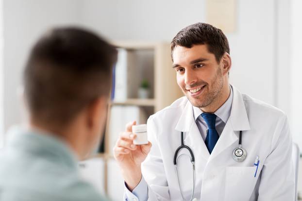 doctor showing medicine to patient at hospital