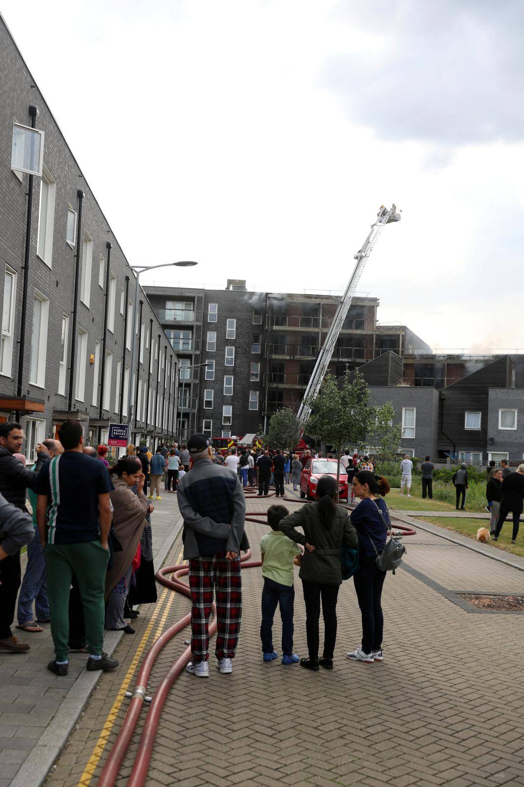 Firefighters work on top of a block of flats after a fire broke out in Barking