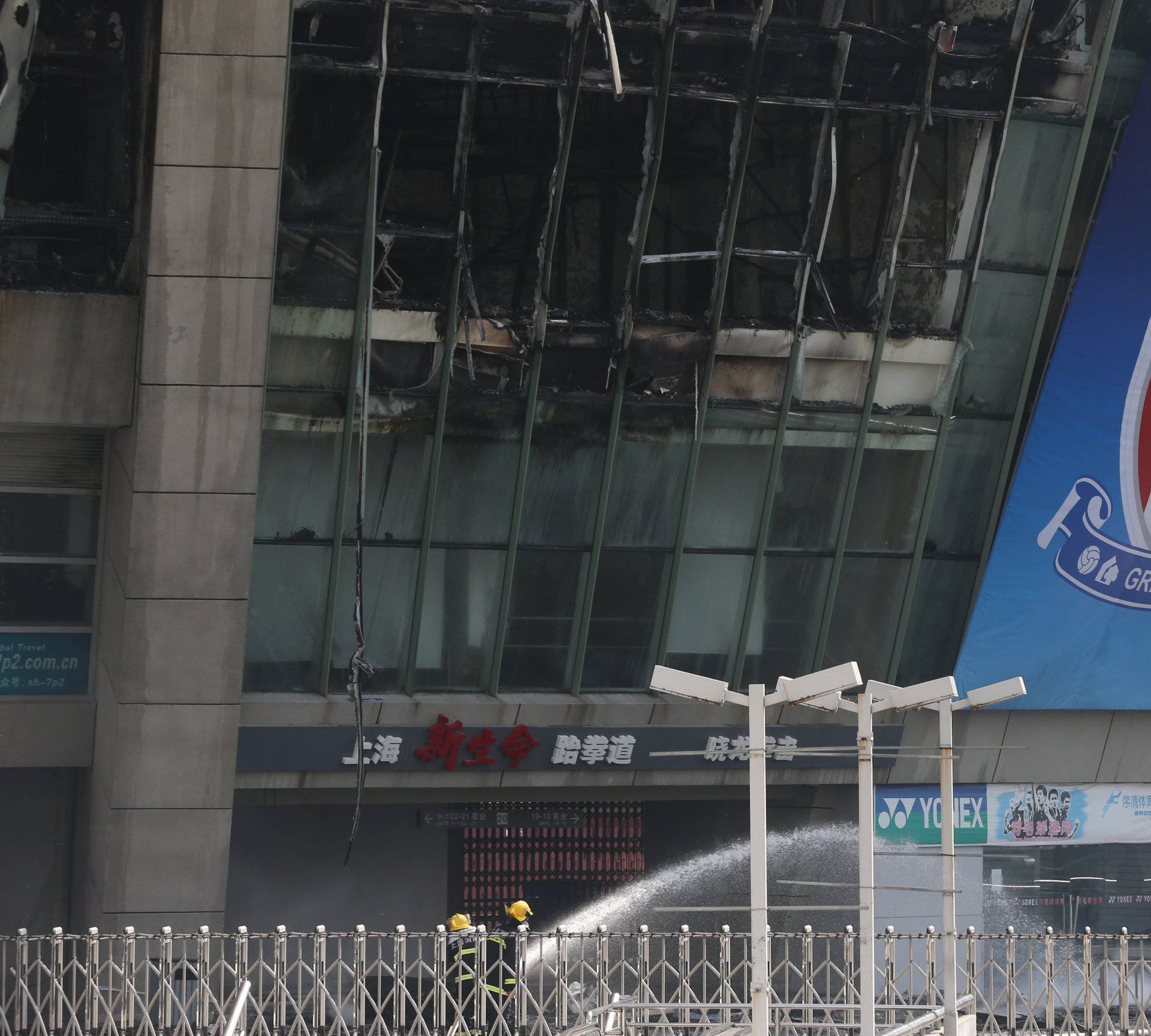 Firefighters are seen outside Hongkou soccer stadium as a fire broke out, in Shanghai