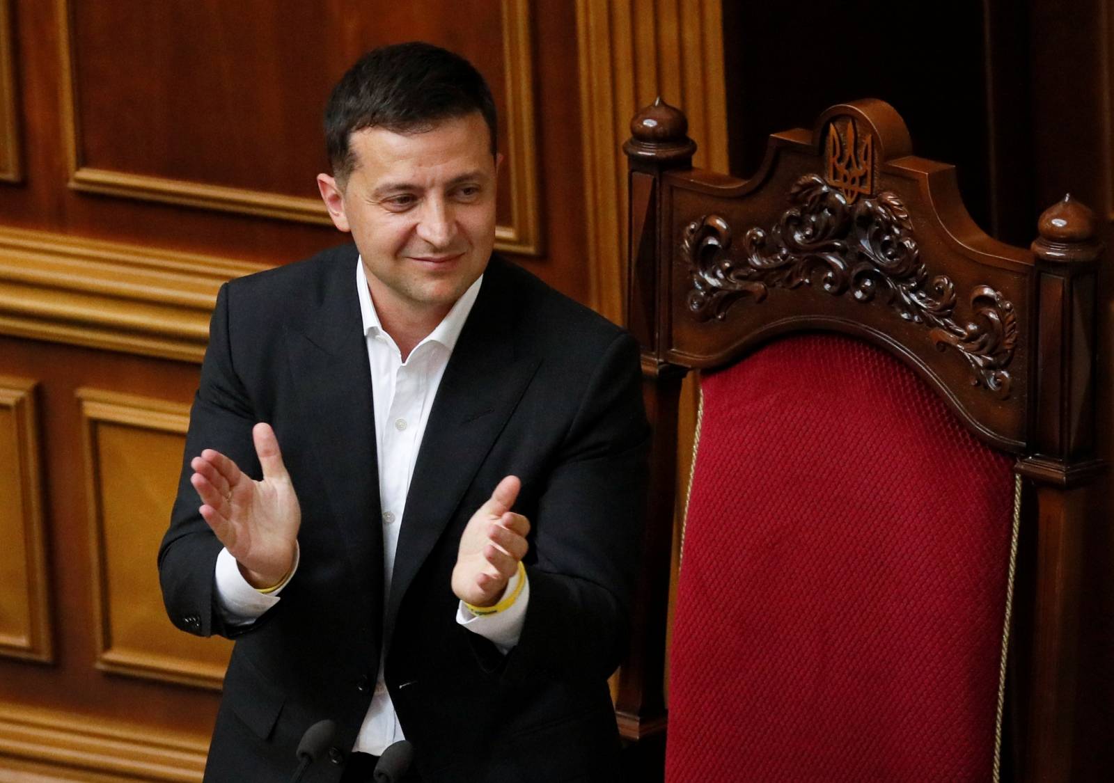 Ukrainian President Volodymyr Zelenskiy applauds during a session of parliament in Kiev