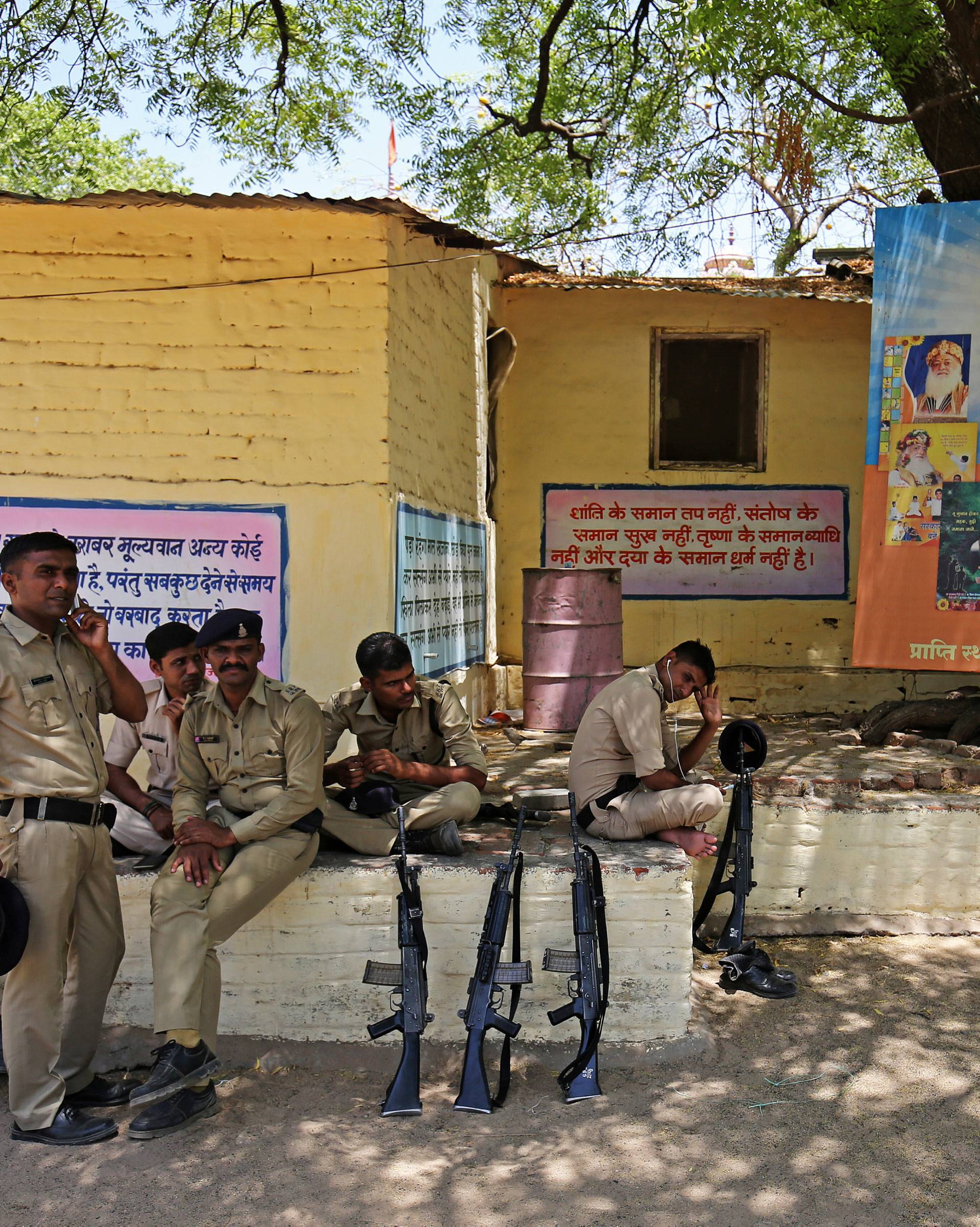 Policemen rest as they guard inside Asaram Bapu's ashram, before a court convicted him for raping a teenage girl, in Ahmedabad