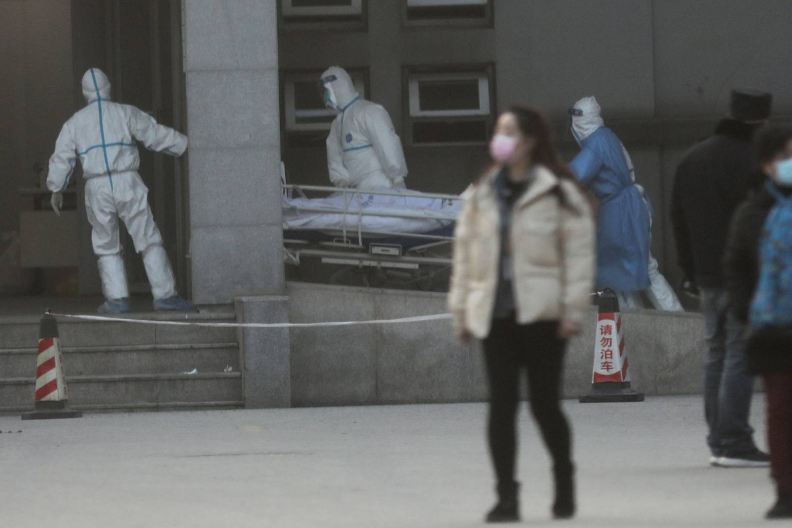 Medical staff transfer a patient at the Jinyintan hospital, where the patients with pneumonia caused by the new strain of coronavirus are being treated, in Wuhan