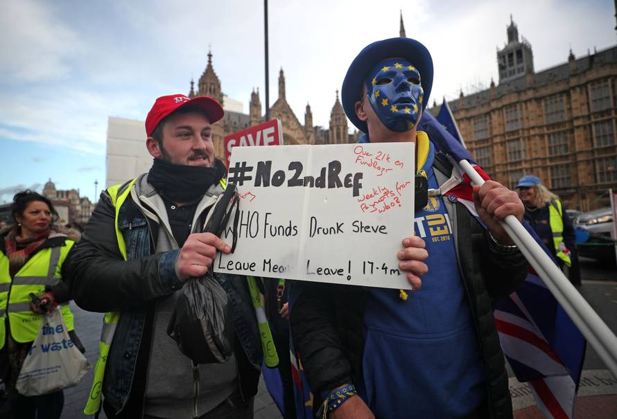 Pro-Brexit and pro-EU supporters hold flags and placards outside the Houses of Parliament in Westminster London