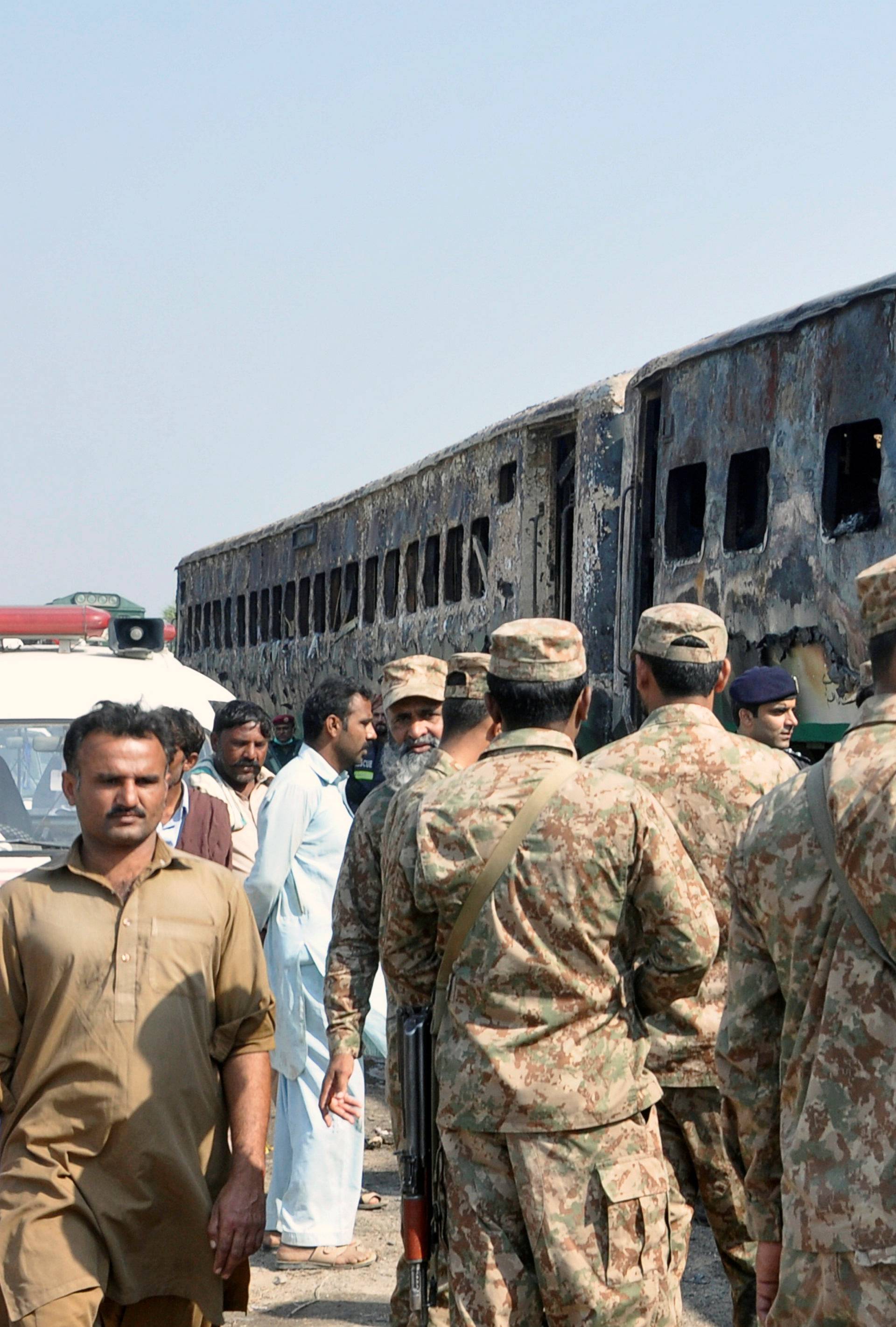 Army soldiers arrive at the place where a fire broke out in a passenger train and destroyed three carriages near the town of Rahim Yar Khan