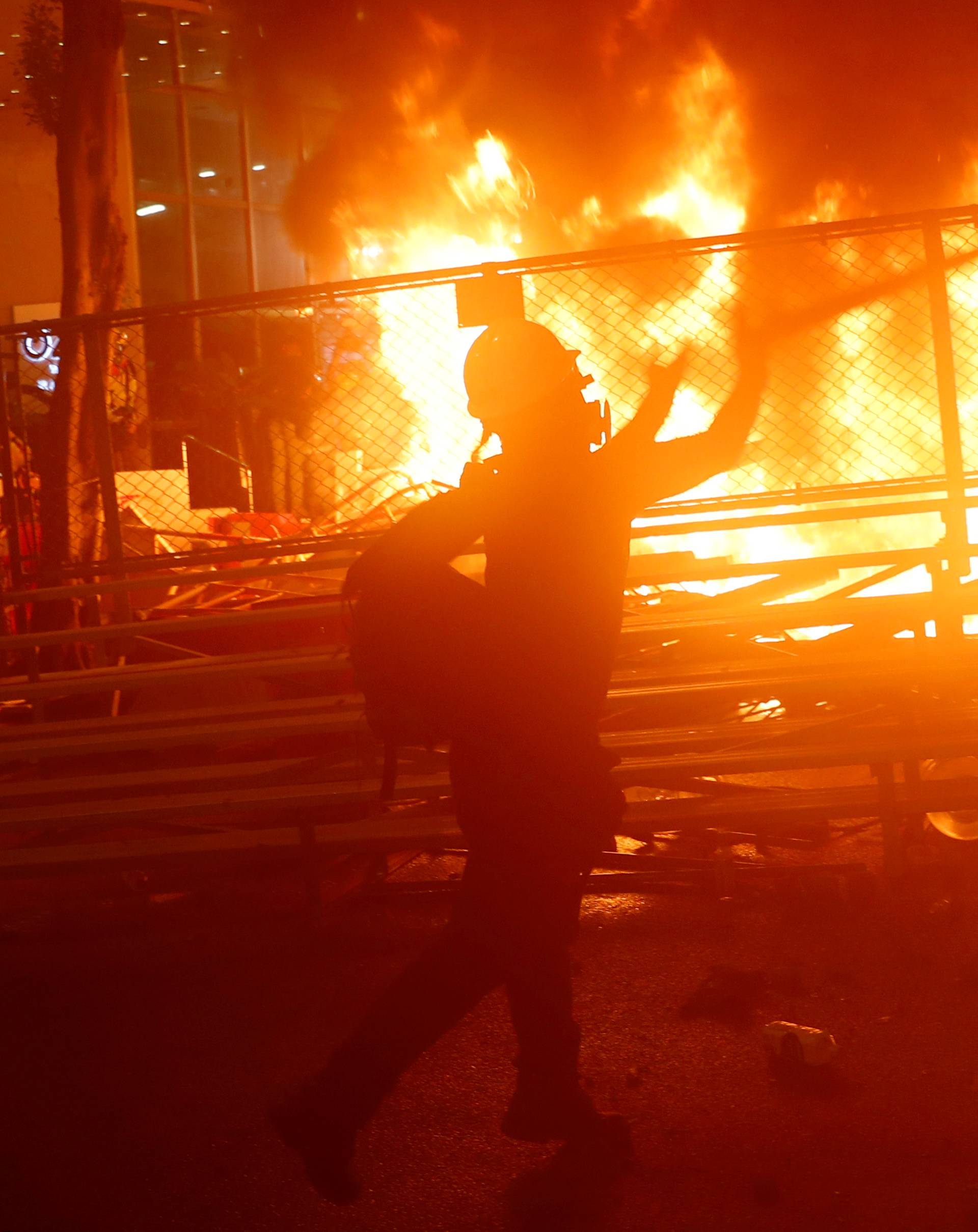 A demonstrator stands next to a burning barricade during a protest in Hong Kong