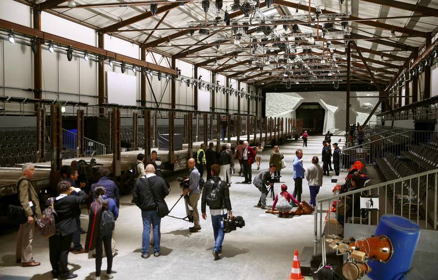 Journalists stand in front of mock gates of the NEAT Gotthard Base Tunnel inside the event hall for the upcoming opening ceremony near the town of Erstfeld