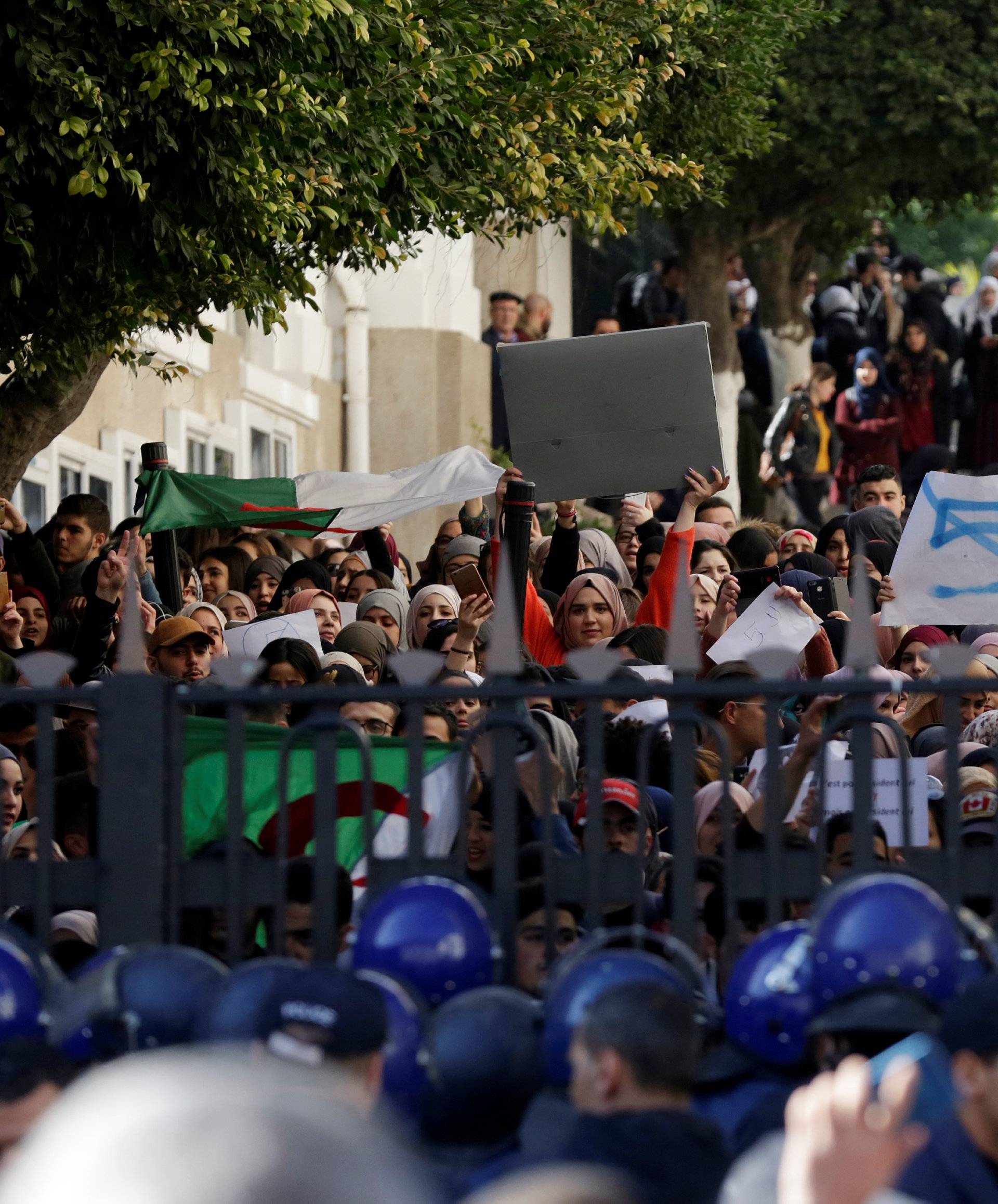 Police block a university's gate while students protest inside the campus against President Abdelaziz Bouteflika's plan to extend his 20-year rule by seeking a fifth term in Algiers