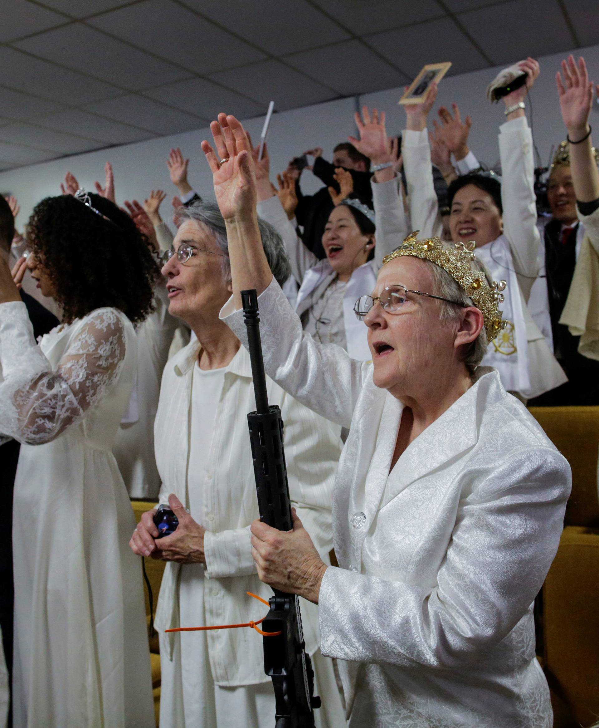 People with their AR-15-style rifles attend a blessing ceremony at the Sanctuary Church in Newfoundland