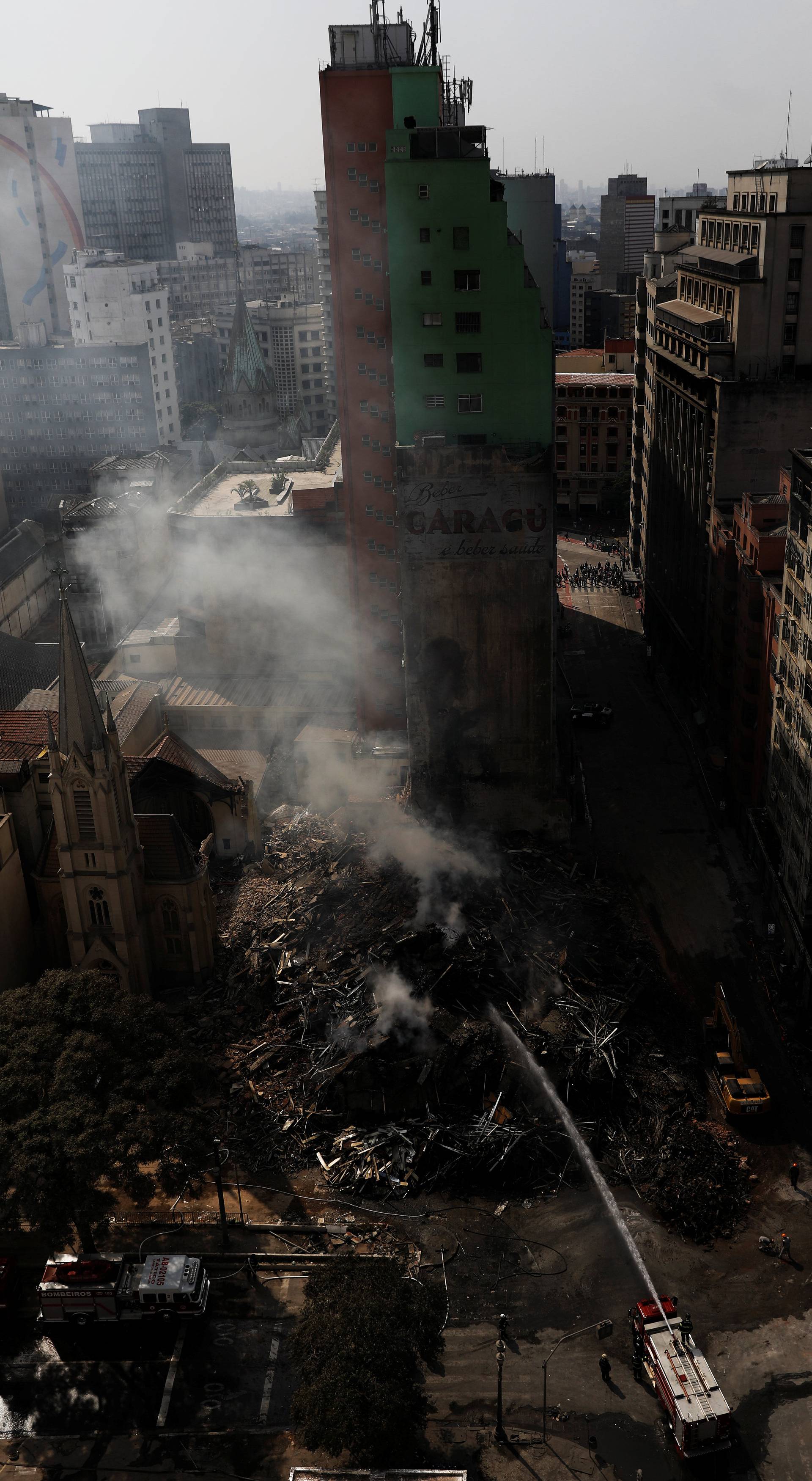 Firefighters try to extinguish the fire of a building that caught fire and collapsed in the center of Sao Paulo