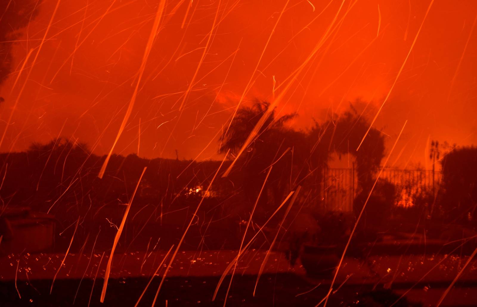 Flying embers fill the night sky to the ground from a wind-driven wild fire called the Saddle Ridge fire in the early morning hours Friday in Porter Ranch