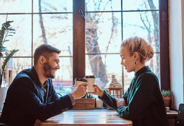 Romantic couple in the cafe is a drinking coffee and talking. 