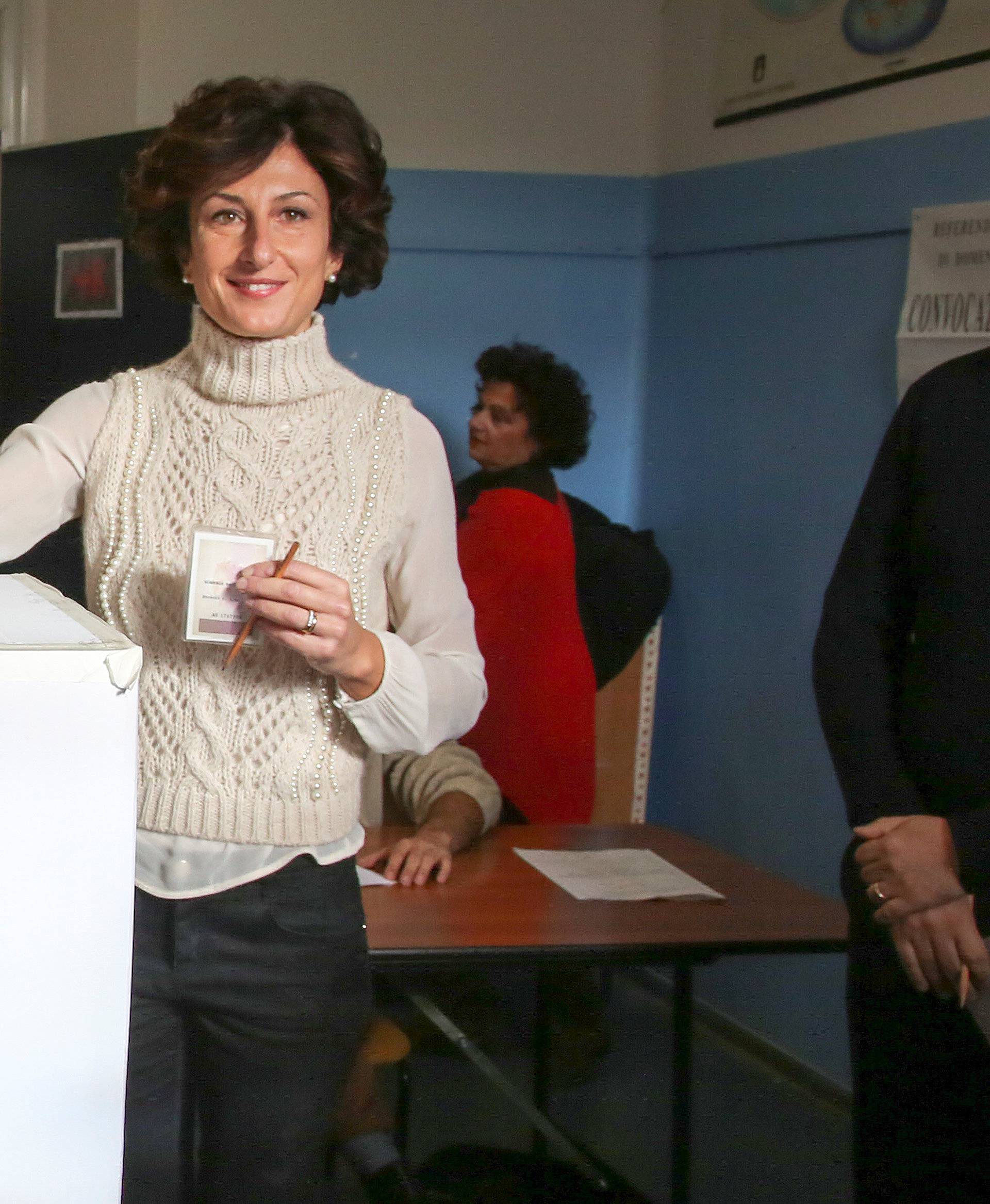 Italian Prime Minister Matteo Renzi looks as his wife Agnese casts his vote for the referendum on constitutional reform, in Pontassieve
