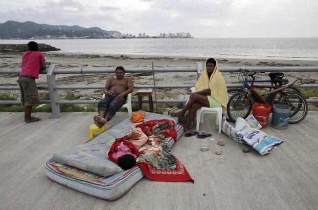 A family rests along Bahia de Caraquez following the earthquake in Ecuador