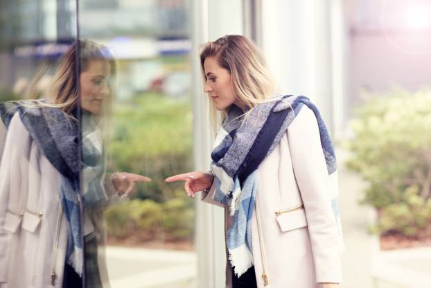 Happy woman window shopping in the city