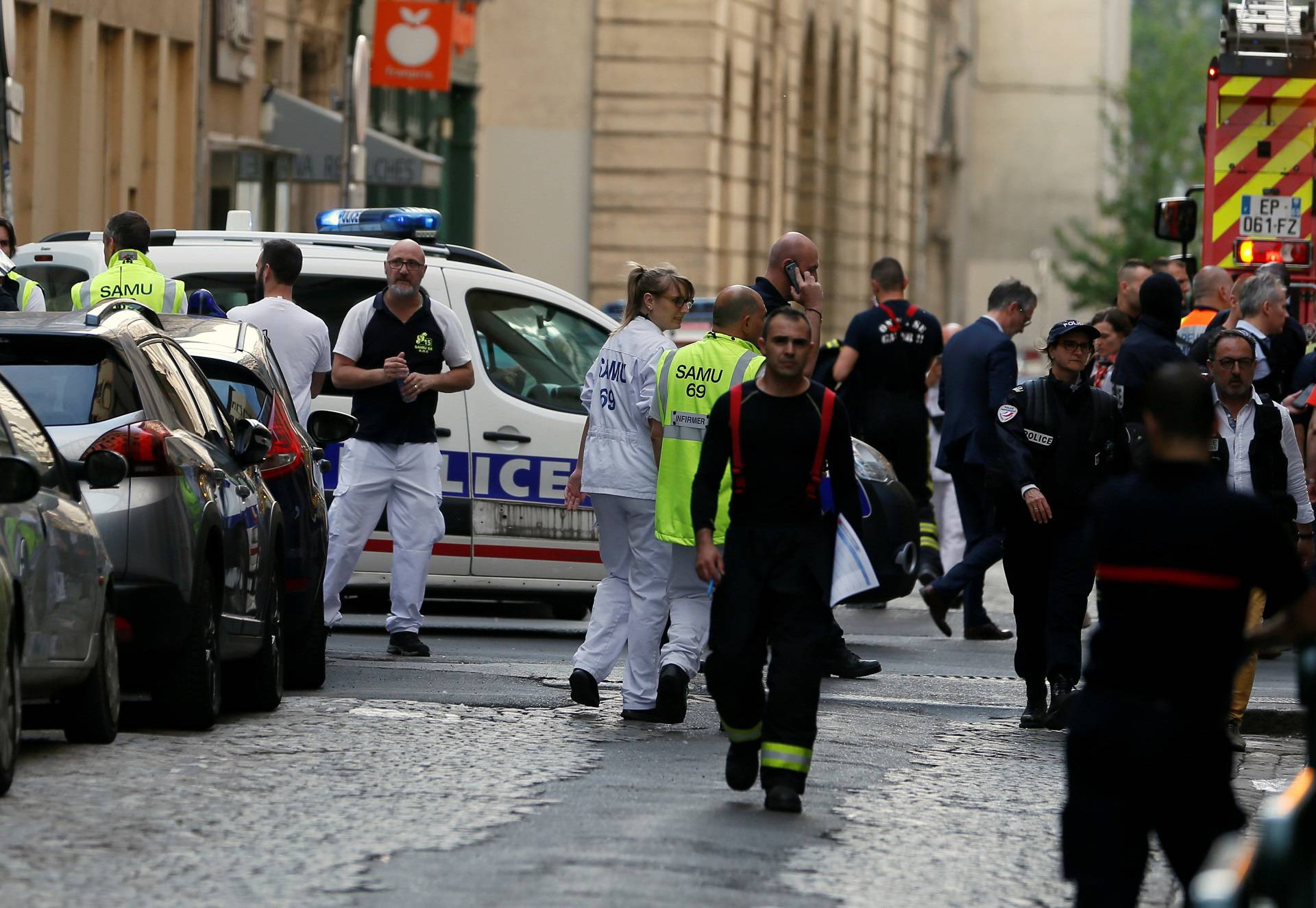 Police officers, fire fighters and medics are seen near the site of a suspected bomb attack in central Lyon