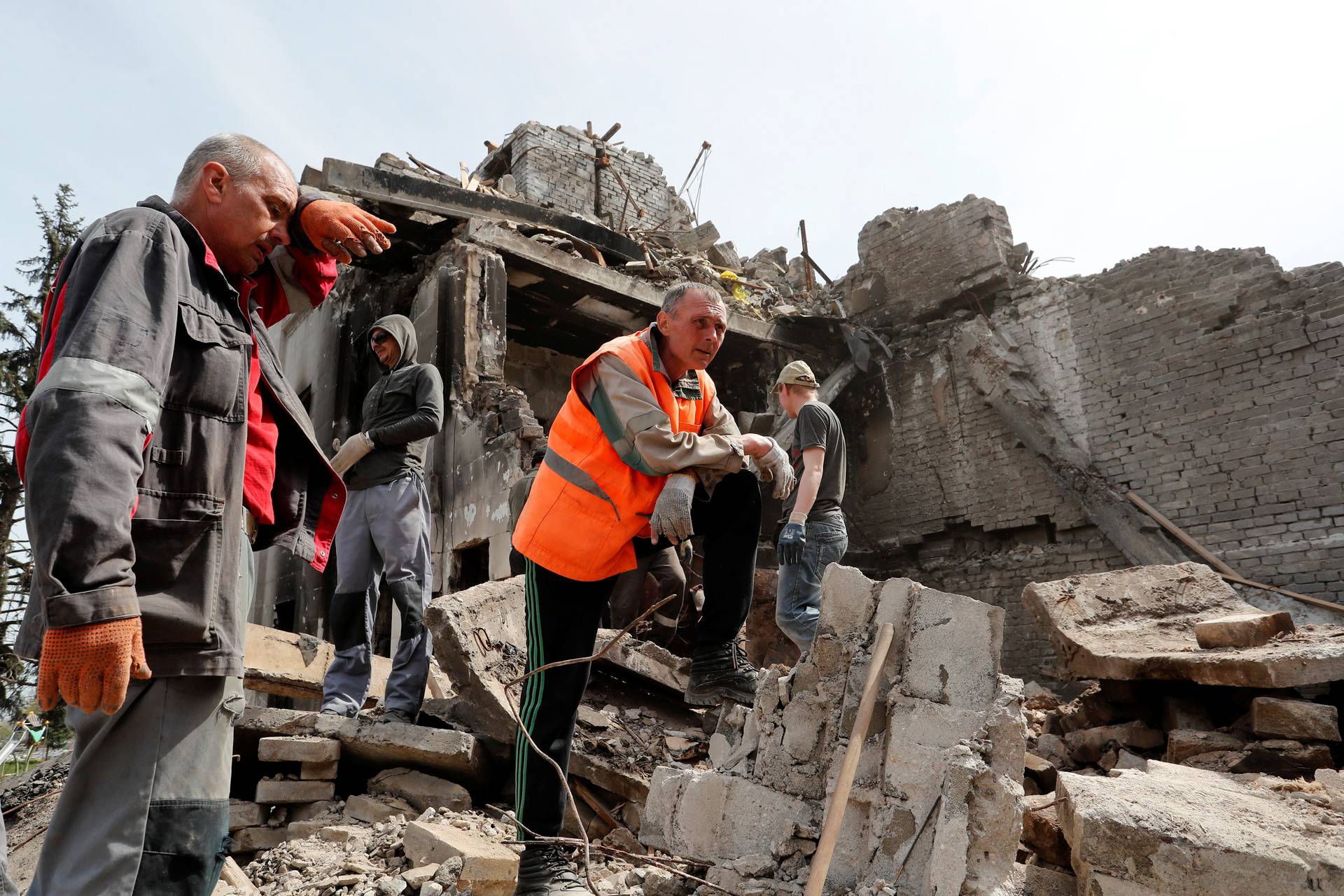 People remove the debris of a theatre building in Mariupol