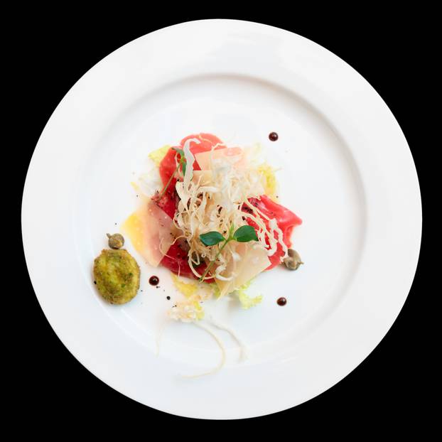 Tuna carpaccio on plate isolated over black