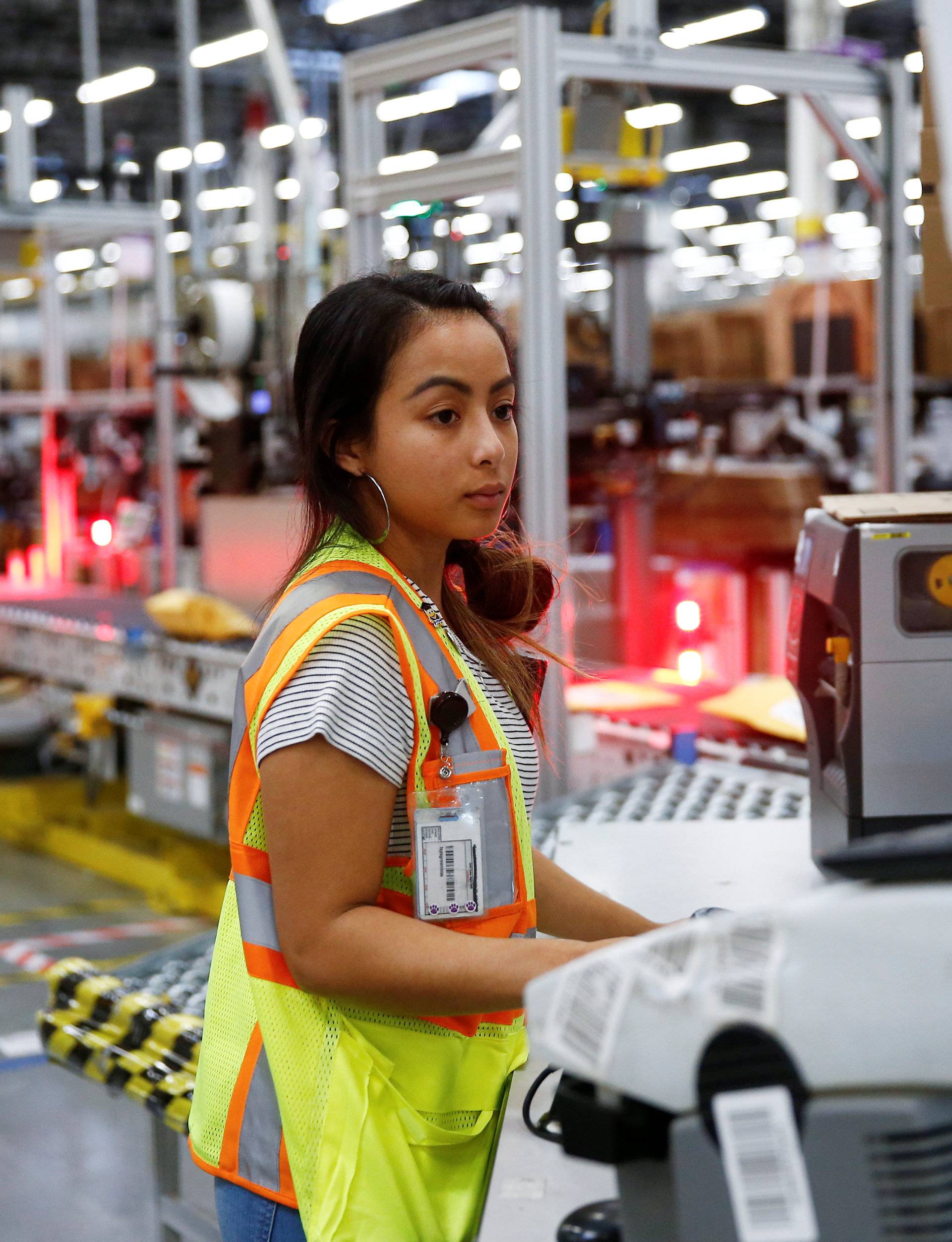 Employee Greenman works on processing packages kicked out by the automated scanning and labeling system at the Amazon fulfillment center in Kent