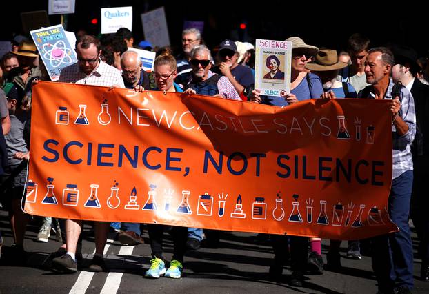 Protesters hold placards and banners as they participate in the March for Science rally on Earth Day, in central Sydney