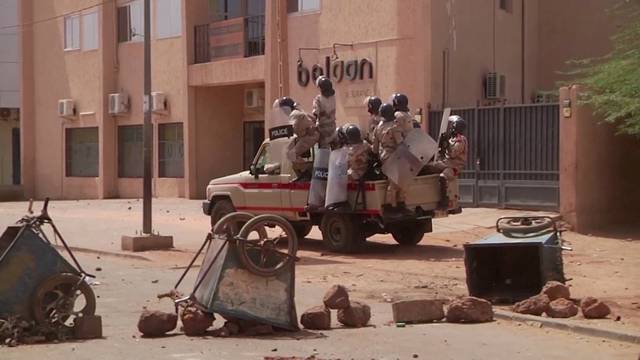 Video grab of riot policemen driving towards protesters at a makeshift checkpoint in Niamey, Niger
