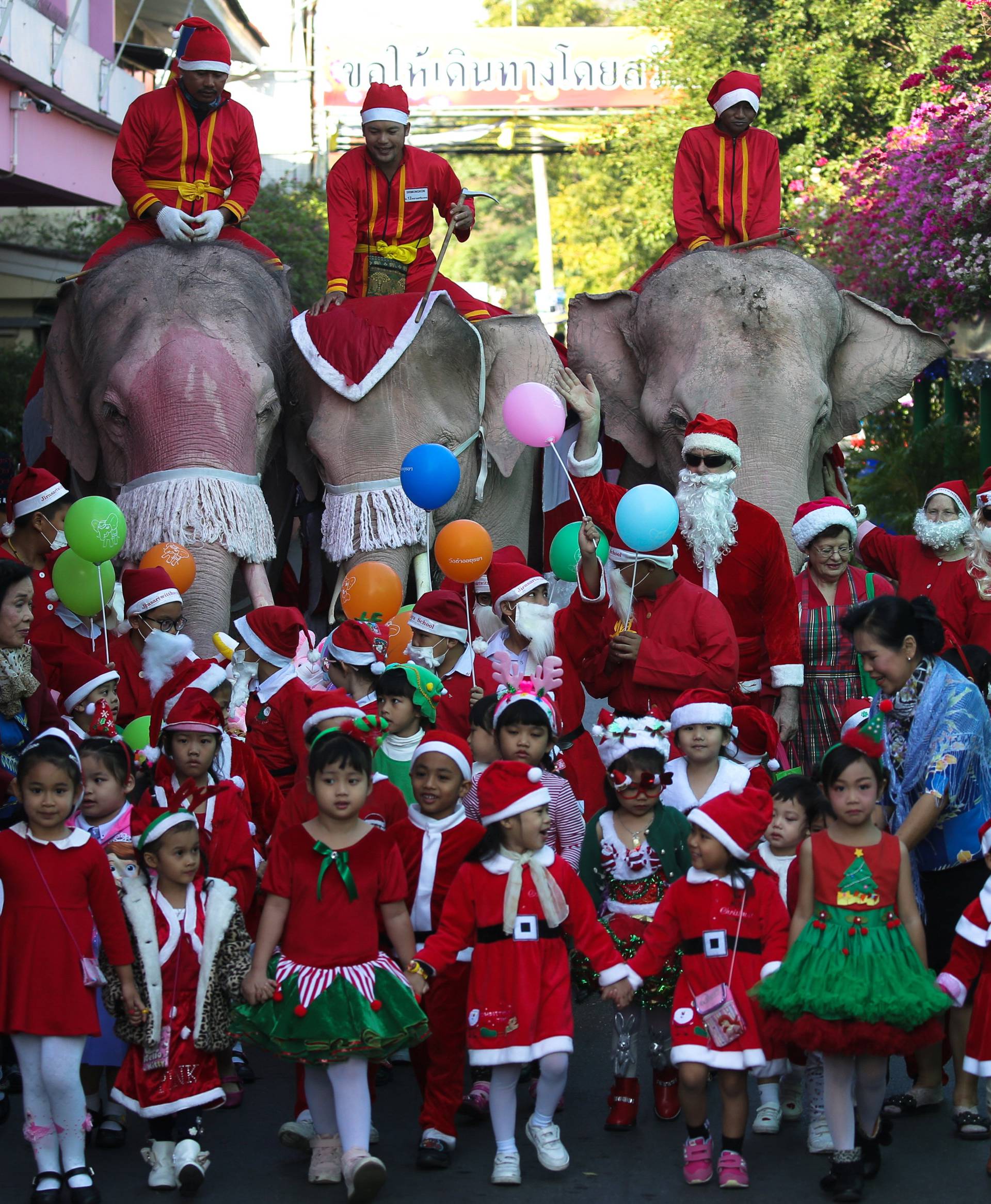 Elephants, teachers and students dressed in Santa Claus costumes parade during Christmas celebrations at Jirasart school in Ayutthaya