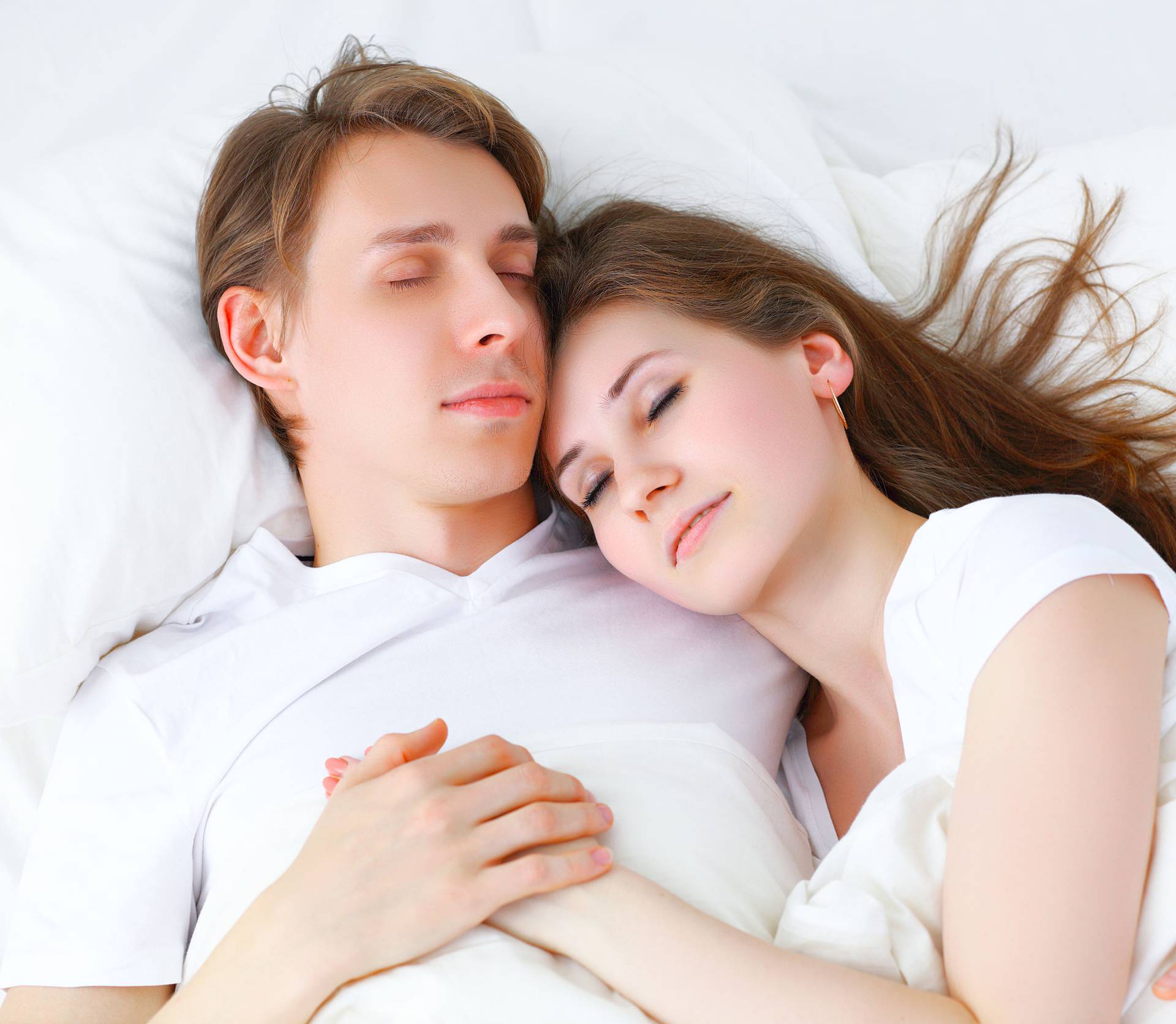 Happy couple  sleeping in bed at home