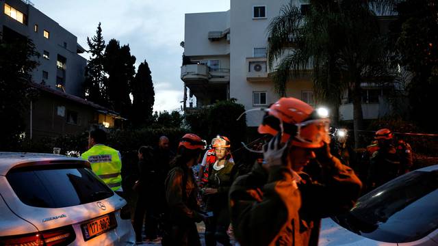 Israeli security and rescue personel work at the scene where a rocket fired from Gaza hit, in Rehovot