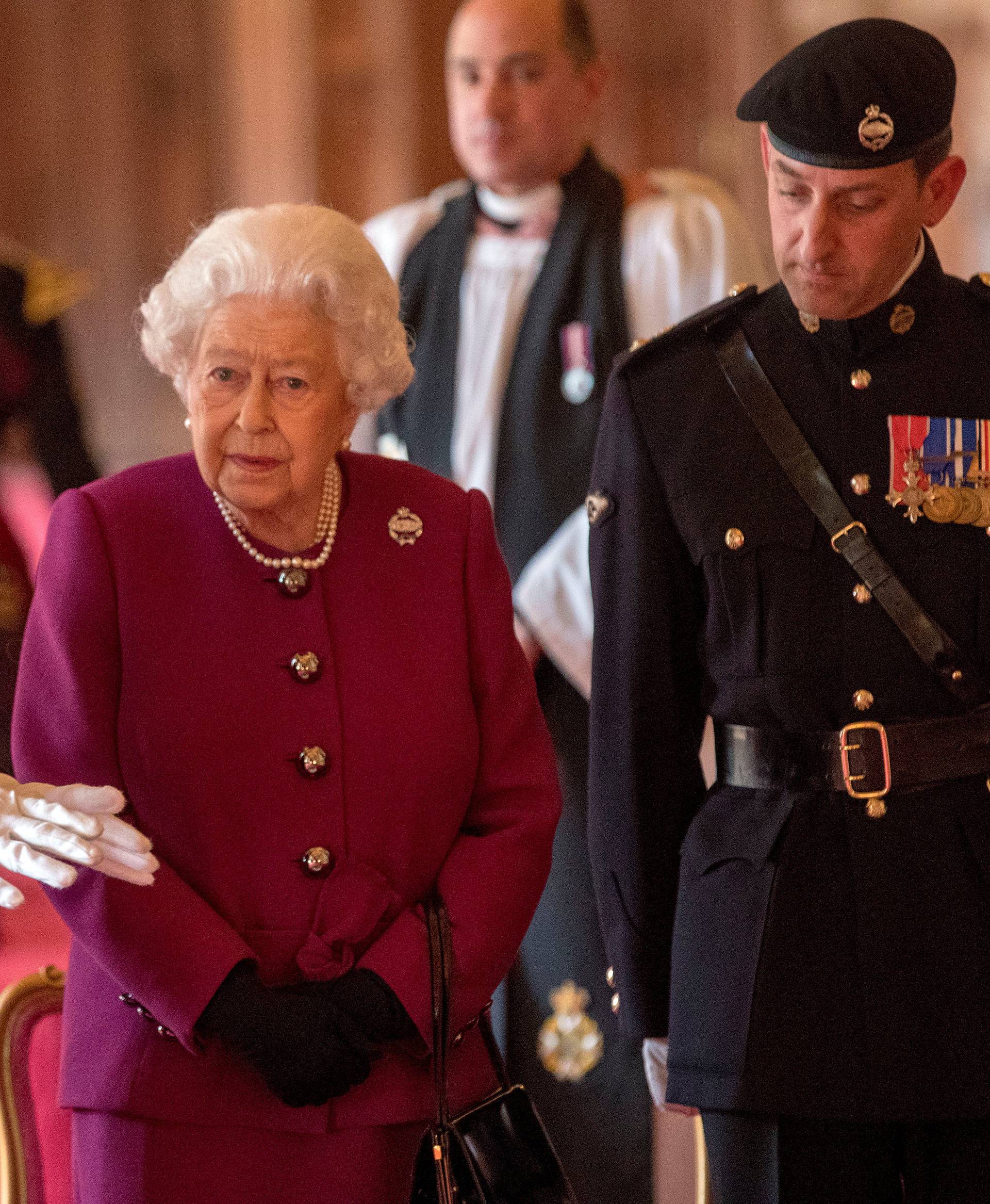 Britain's Queen Elizabeth, Colonel-in-Chief of the Royal Tank Regiment, poses for a photograph after presenting the regiment with their new standard in St George's Hall at Windsor Castle in Windsor