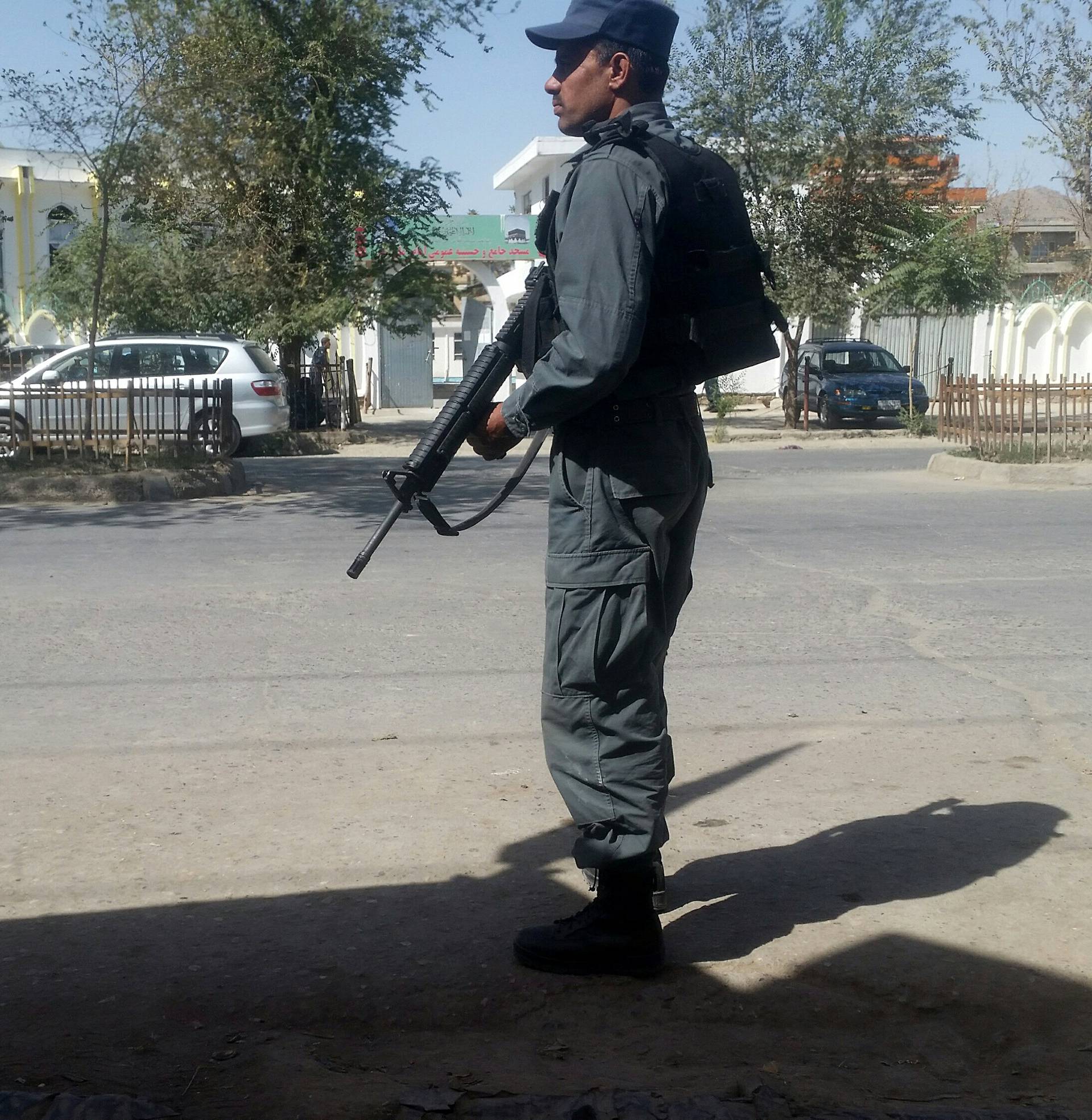 An Afghan policeman keeps guard the the site of attack in Kabul