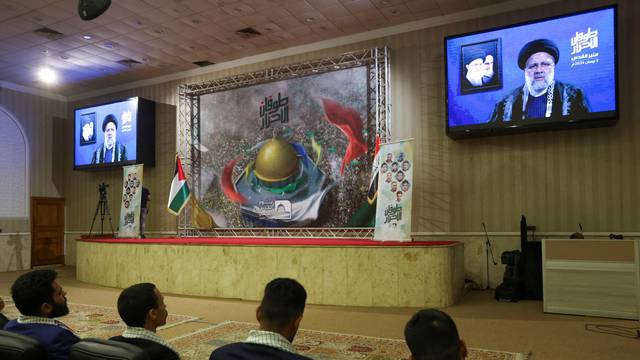 Supporters of Iraqi Shi'ite armed groups watch a televised speech by Iranian President Ebrahim Raisi, ahead of Al-Quds (Jerusalem) Day, in Baghdad