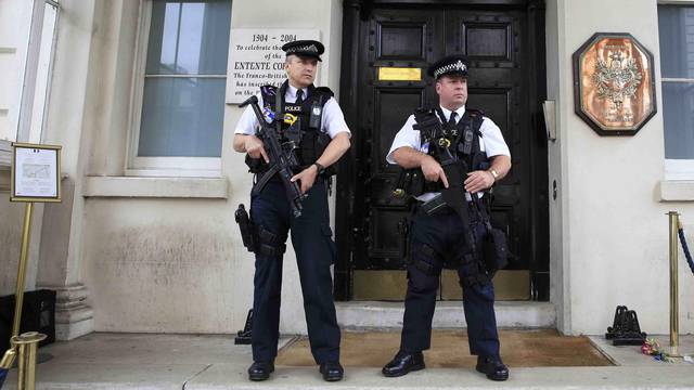 Armed police stand guard outside the French embassy in London