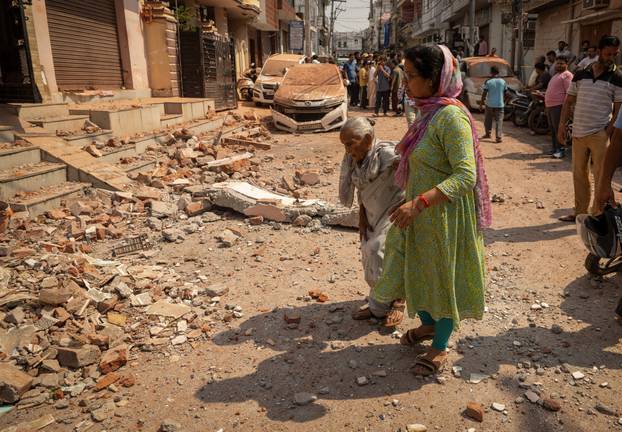 Women walk towards their damaged house, following Pakistan's military operation against India, in Rehari, Jammu