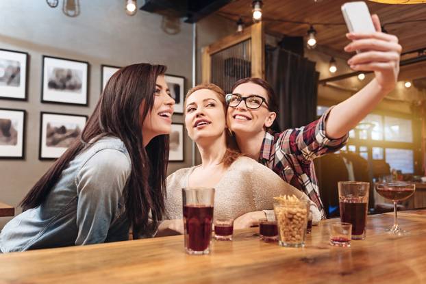Company of three people making photo